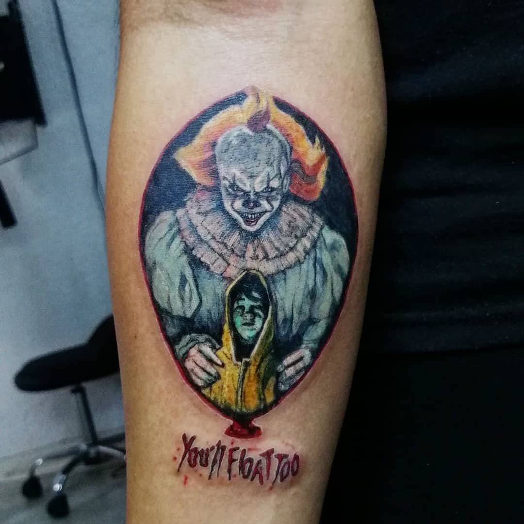 Tattoo of Pennywise with Georgie in the background, with "You'll Float Too" text below